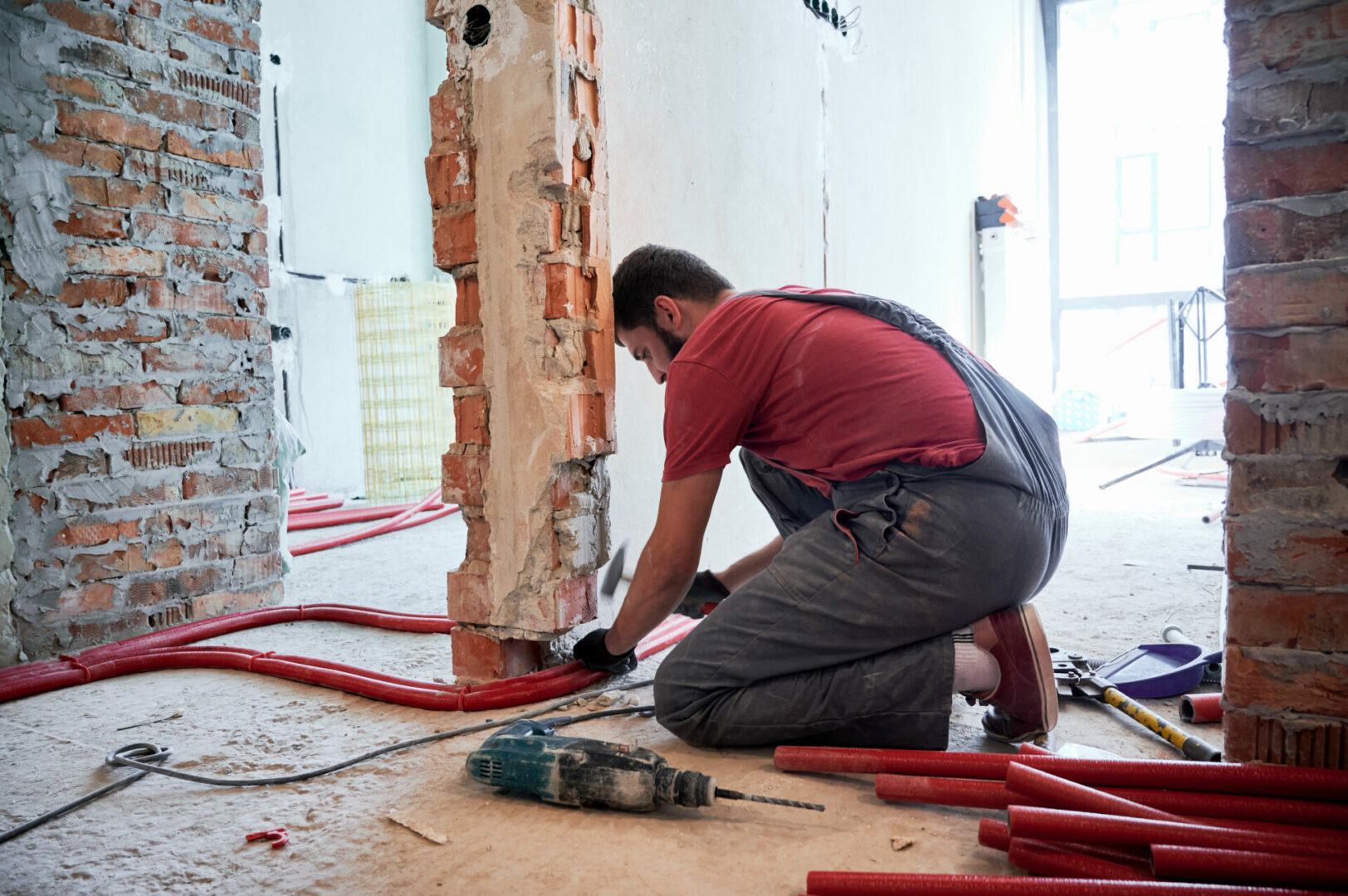 Bearded young man installing heating system in apartment.