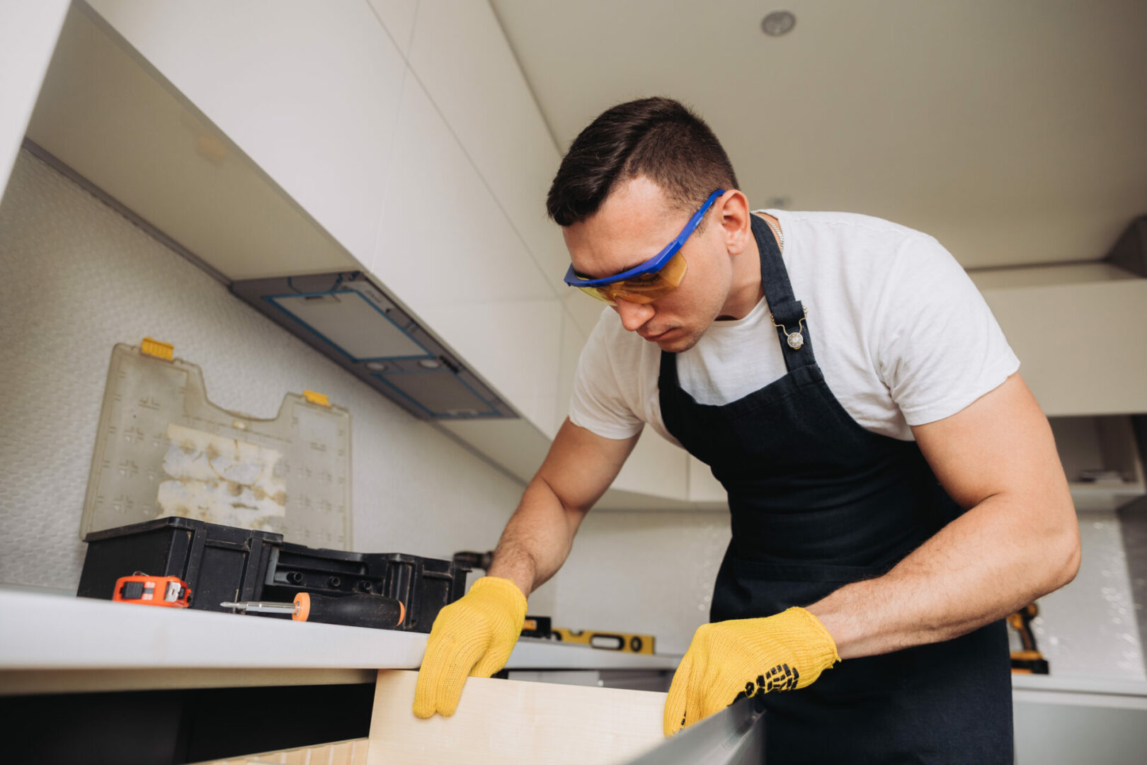 Maintenance man installing kitchen furniture